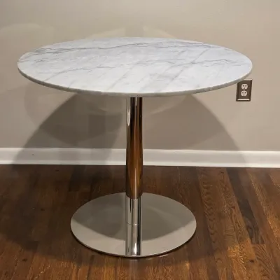 Sale Photo Thumbnail #49: Modern round bistro table featuring a grey-veined white marble top supported by a polished chrome pedestal and disc base.