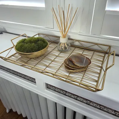 Sale Photo Thumbnail #119: Modern gold wire metal decorative tray featuring geometric lattice details, holding a small gold bowl with preserved moss, a reed diffuser, and a set of polished agate slice coasters.