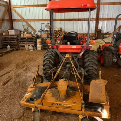 Sale Photo Thumbnail #10: Woods RM550 rear-mount finish mower attached to an orange Kubota sub-compact tractor with a canopy