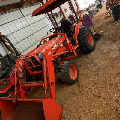 Sale Photo Thumbnail #9: Orange Kubota LA402 sub-compact tractor with front-end loader attachment and overhead canopy