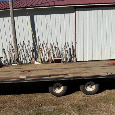 Sale Photo Thumbnail #49: Dual-axle flatbed utility trailer with a wooden deck