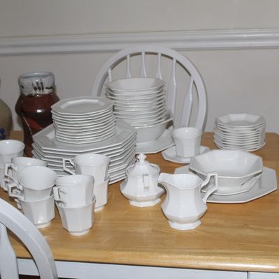 Sale Photo Thumbnail #60: Vintage white ironstone dinnerware set featuring an octagonal design, including plates, bowls, cups, saucers, a creamer, and a sugar bowl, displayed alongside several studio pottery vessels.