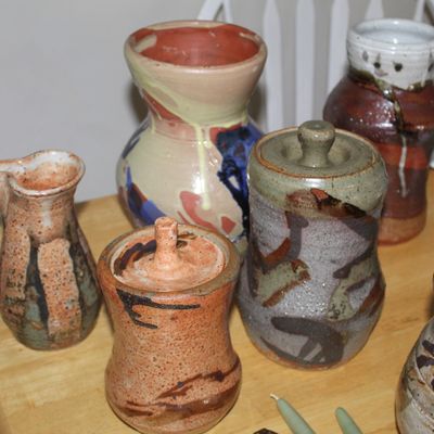 Sale Photo Thumbnail #62: Collection of studio art pottery, including lidded jars, vases, and a small pitcher, featuring earthy glazes and hand-thrown details.