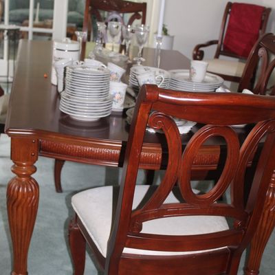 Sale Photo Thumbnail #89: Traditional cherry-finished dining table with fluted legs, paired with matching upholstered dining chairs featuring a decorative oval back design.