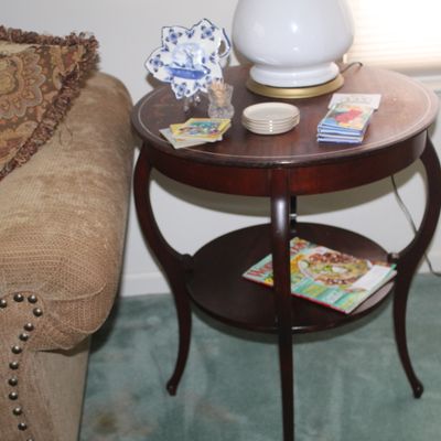 Sale Photo Thumbnail #22: Traditional round mahogany side table featuring curved legs, a lower display shelf, and light inlay detailing on the tabletop.