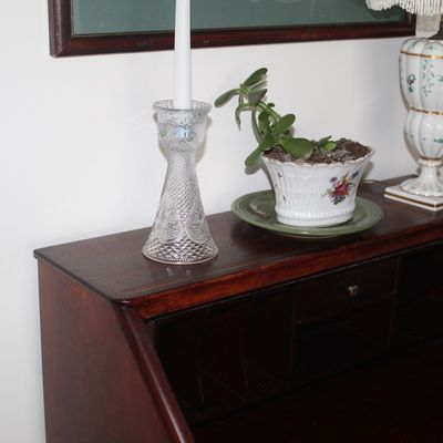 Sale Photo Thumbnail #83: Vintage mahogany slant-front secretary desk, styled with a cut glass candlestick, a small potted jade plant, and a floral porcelain table lamp.