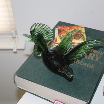 Sale Photo Thumbnail #46: Vintage green art glass rooster figurine, displayed on top of a vintage dictionary.