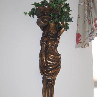 Sale Photo Thumbnail #122: Classical caryatid wall pocket planter in a bronzed finish, holding faux ivy.