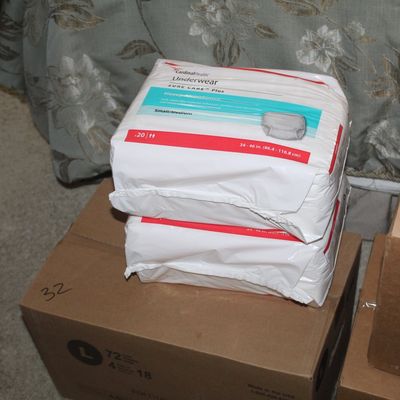 Sale Photo Thumbnail #108: Two unopened packages of Cardinal Health Sure Care Plus protective underwear, size small/medium, stacked on cardboard boxes.