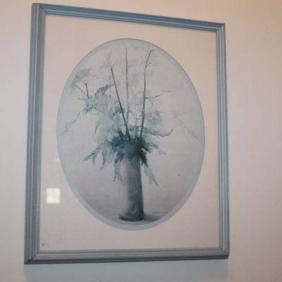 Sale Photo Thumbnail #123: Framed watercolor painting depicting a floral arrangement in a vase, rendered in muted blue and grey tones within an oval mat and a simple blue frame.
