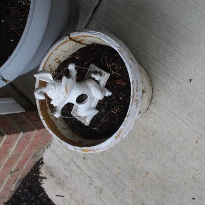 Sale Photo Thumbnail #2: Weathered white ceramic planter containing soil and a small white rabbit figurine on a swing.