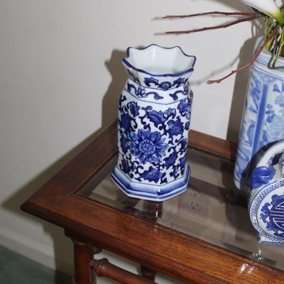 Sale Photo Thumbnail #11: Small blue and white porcelain vase with a scalloped rim and floral motif, displayed on a wooden side table.