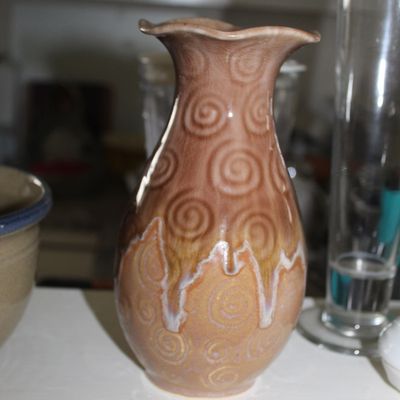 Sale Photo Thumbnail #92: Art pottery vase featuring a ruffled rim, spiral patterns, and a multi-toned brown and tan drip glaze.