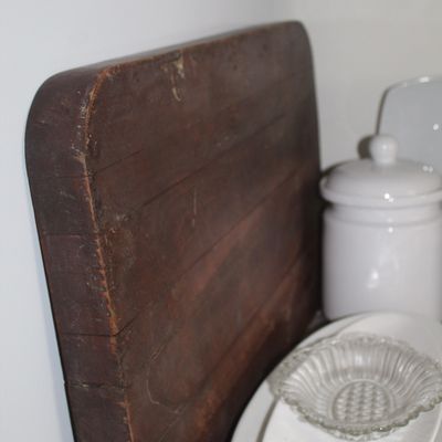Sale Photo Thumbnail #102: Vintage thick wooden cutting board with a dark patina, displayed alongside white ceramic serving dishes and a small clear glass bowl.