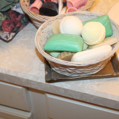 Sale Photo Thumbnail #107: Small woven wicker basket filled with decorative soaps and bath bombs, displayed on a bathroom vanity.