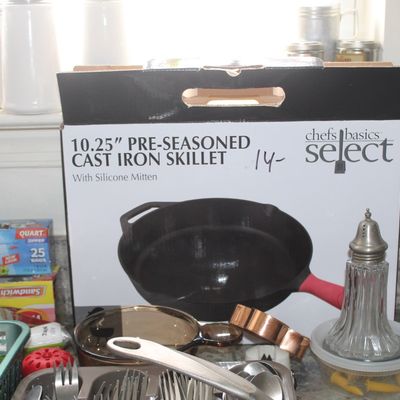 Sale Photo Thumbnail #121: Chef's Basics Select 10.25-inch pre-seasoned cast iron skillet, new in box, displayed alongside various kitchen utensils and glassware.