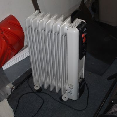 Sale Photo Thumbnail #56: DeLonghi oil-filled radiator space heater on wheels, showing light wear from use.