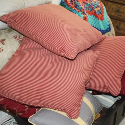Sale Photo Thumbnail #119: Trio of red and beige striped square throw pillows, shown piled on a bed alongside other decorative cushions.