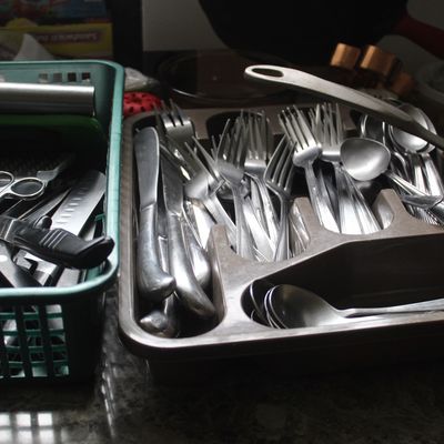 Sale Photo Thumbnail #99: Assorted stainless steel flatware and kitchen utensils organized in plastic storage trays.