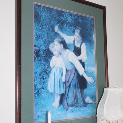 Sale Photo Thumbnail #81: Framed print of William-Adolphe Bouguereau's "The Storm" (or "The Stormy Weather"), featuring three children in a forest, matted in green and housed in a dark wood frame.