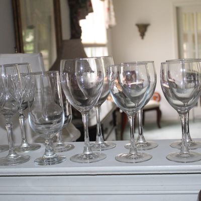 Sale Photo Thumbnail #95: Assorted clear glass stemware, including wine glasses and goblets, displayed on a shelf.