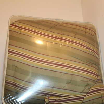Sale Photo Thumbnail #51: Striped comforter in shades of green, brown, and cream, stored in its original clear zippered plastic packaging.