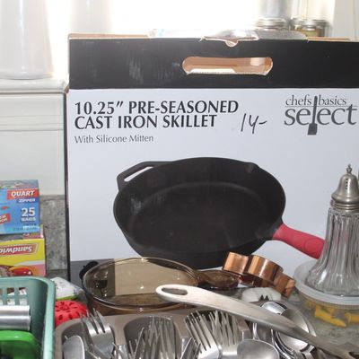 Sale Photo Thumbnail #100: Chefs Basics Select 10.25-inch pre-seasoned cast iron skillet in its original box, shown alongside various kitchen utensils, a Pyrex measuring cup, and a glass sugar shaker.