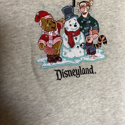 Sale Photo Thumbnail #445: Disneyland Resort hooded sweatshirt featuring an embroidered front design of Winnie the Pooh, Tigger, Piglet, and a snowman with 'Disneyland' embroidered below. Features front side-entry pockets, a fleece-lined hood with drawstring, and an adjustable draw