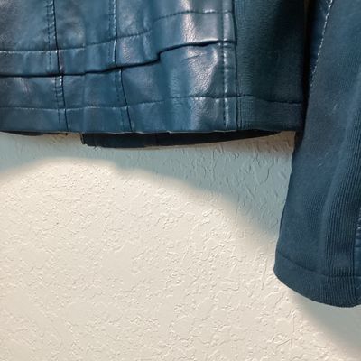 Sale Photo Thumbnail #514: Women's teal blue faux leather moto-style jacket by Baccini. Features a front zip closure, snap collar, quilted details on sleeves and shoulders, stretchy knit side panels, and zippered cuffs. Fully lined. Appears to be in good condition. Women’s medium