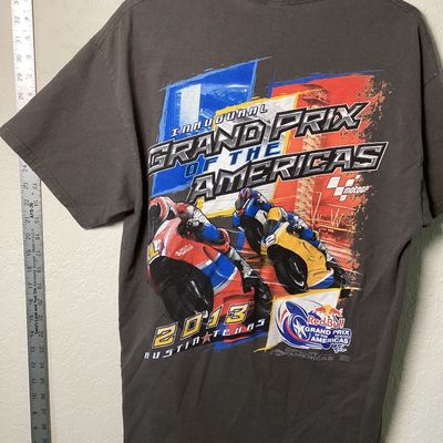 Sale Photo Thumbnail #527: Short sleeve gray T-shirt commemorating the Inaugural Red Bull Grand Prix of the Americas held in 2013 at the Circuit of the Americas in Austin, Texas. Features bold front and back motorcycle racing graphics with MotoGP logos.

- Size: Large (L / G)
- Mat