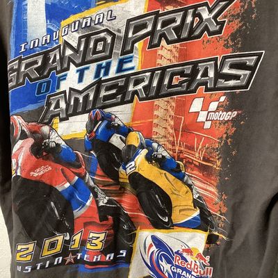 Sale Photo Thumbnail #528: Short sleeve gray T-shirt commemorating the Inaugural Red Bull Grand Prix of the Americas held in 2013 at the Circuit of the Americas in Austin, Texas. Features bold front and back motorcycle racing graphics with MotoGP logos.

- Size: Large (L / G)
- Mat