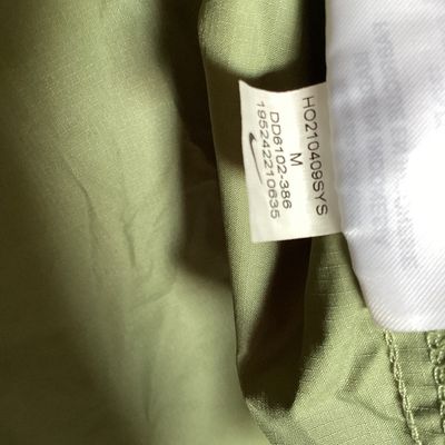 Sale Photo Thumbnail #489: Men's Nike Running Division Therma-Fit hooded full-zip jacket in olive green with patterned light green panels and sleeves. Style code DD6102-386. Features front hand pockets, adjustable hood drawstrings, and reflective Nike swoosh logo on the chest. Size
