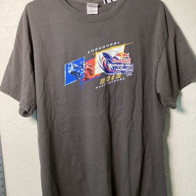 Sale Photo Thumbnail #524: Short sleeve gray T-shirt commemorating the Inaugural Red Bull Grand Prix of the Americas held in 2013 at the Circuit of the Americas in Austin, Texas. Features bold front and back motorcycle racing graphics with MotoGP logos.

- Size: Large (L / G)
- Mat