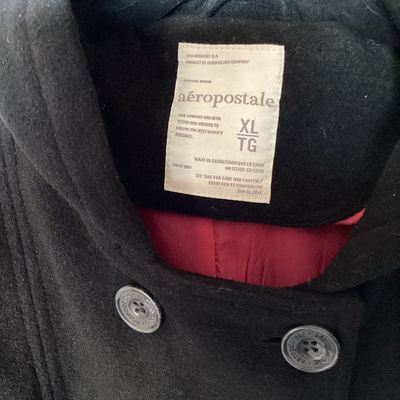 Sale Photo Thumbnail #492: Aeropostale black double-breasted hooded pea coat, women's size XL Features front button closure, side slip pockets, buttoned sleeve cuffs, rear button strap detail, and a bright pink inner. Length measures approximately 26 inches. In good pre-owned condi