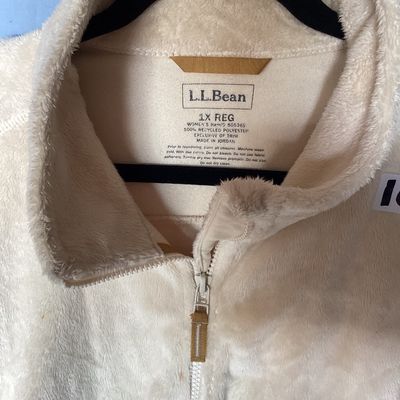 Sale Photo Thumbnail #477: L.L. Bean women's full-zip plush fleece jacket in cream. Made from 100% recycled polyester. Features zipper hand pockets and tan accent zipper pulls. Length measures approximately 27-28 inches. Overall good pre-owned condition with some minor discoloratio