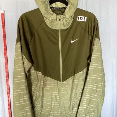 Sale Photo Thumbnail #485: Men's Nike Running Division Therma-Fit hooded full-zip jacket in olive green with patterned light green panels and sleeves. Style code DD6102-386. Features front hand pockets, adjustable hood drawstrings, and reflective Nike swoosh logo on the chest. Size