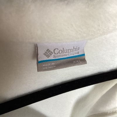 Sale Photo Thumbnail #456: White full-zip soft fleece jacket by Columbia Sportswear Company. Features a high collar, full front zipper, embroidered Columbia patch logo on the chest, and elastic cuffs. Tag size is XXL, made in Vietnam. Measures approximately 26 inches in length from