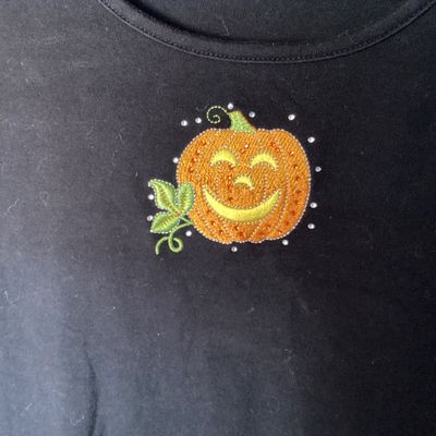 Sale Photo Thumbnail #467: Black long sleeve shirt by Quacker Factory by Jeanne Bice featuring an embroidered and beaded jack-o'-lantern pumpkin design on the chest. Size XL. Good pre-owned condition with light wear consistent with normal use. Length measures approximately 27-28 in