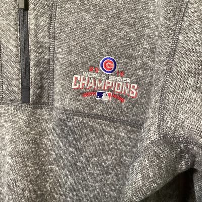 Sale Photo Thumbnail #518: Antigua brand men's size XL heather gray quarter-zip fleece pullover featuring an embroidered Chicago Cubs 2016 World Series Champions emblem on the left chest. Features a zip pocket on the left sleeve and a stand-up collar. In good used condition with li