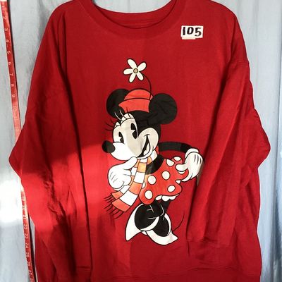 Sale Photo Thumbnail #460: Red crewneck Disney sweatshirt featuring a graphic print of Minnie Mouse in a scarf and skirt with a flower hat. Size tag states 1X. Made of a cotton blend. Shows light wear consistent with pre-owned condition, including some loose threads near the bottom