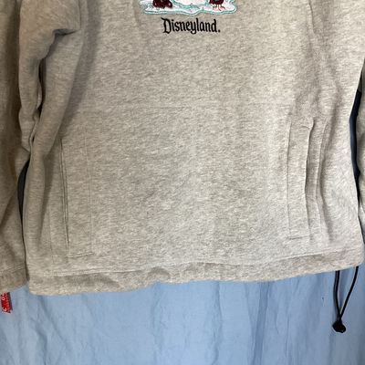 Sale Photo Thumbnail #449: Disneyland Resort hooded sweatshirt featuring an embroidered front design of Winnie the Pooh, Tigger, Piglet, and a snowman with 'Disneyland' embroidered below. Features front side-entry pockets, a fleece-lined hood with drawstring, and an adjustable draw