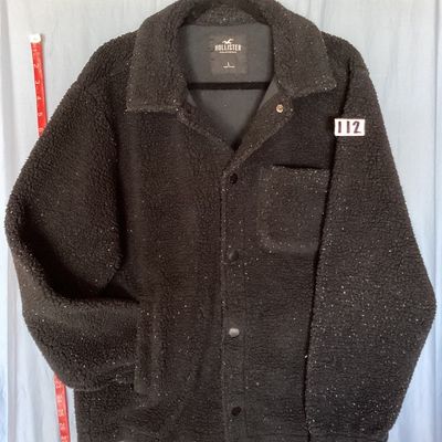 Sale Photo Thumbnail #423: Hollister California fleece sherpa jacket in men's size Large. Features a dark black fabric with white flecked detailing throughout, front snap/button closure, chest patch pocket, side hand pockets, and a collared neckline. Appears to be in good pre-owned