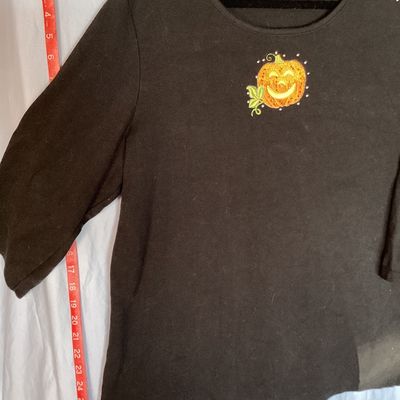 Sale Photo Thumbnail #468: Black long sleeve shirt by Quacker Factory by Jeanne Bice featuring an embroidered and beaded jack-o'-lantern pumpkin design on the chest. Size XL. Good pre-owned condition with light wear consistent with normal use. Length measures approximately 27-28 in