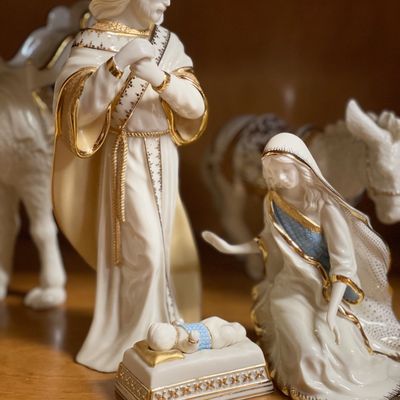 Sale Photo Thumbnail #208: Lenox porcelain nativity set featuring Mary, Joseph, and baby Jesus, accented with 24k gold trim and blue details.