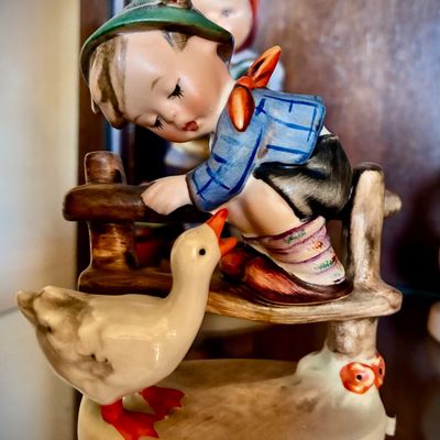 Sale Photo Thumbnail #39: Vintage Goebel Hummel figurine titled "Culprits" (Hum 56/A), featuring a young boy on a fence looking down at a goose, in excellent condition.