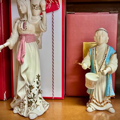 Sale Photo Thumbnail #140: Two Lenox porcelain figurines from the First Blessing Nativity collection, featuring a woman carrying a water jug and a drummer boy, both with original boxes.