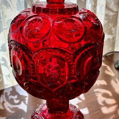 Sale Photo Thumbnail #34: Vintage ruby red glass lidded candy dish in the Moon and Stars pattern, featuring a pedestal base and matching finial lid.