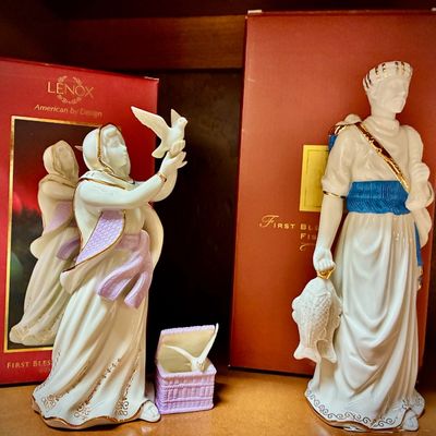Sale Photo Thumbnail #131: Two Lenox "First Blessing" Nativity porcelain figurines, including a woman releasing a dove and a fisherman holding a fish, both with gold accents and original red boxes.