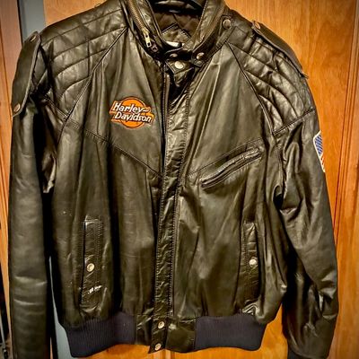 Sale Photo Thumbnail #10: Vintage Harley-Davidson black leather bomber jacket featuring quilted shoulder details, embroidered chest logo, and an American flag patch on the sleeve.