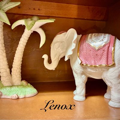 Sale Photo Thumbnail #189: Lenox porcelain elephant figurine with a pink and gold saddle, displayed alongside a matching porcelain palm tree figurine.